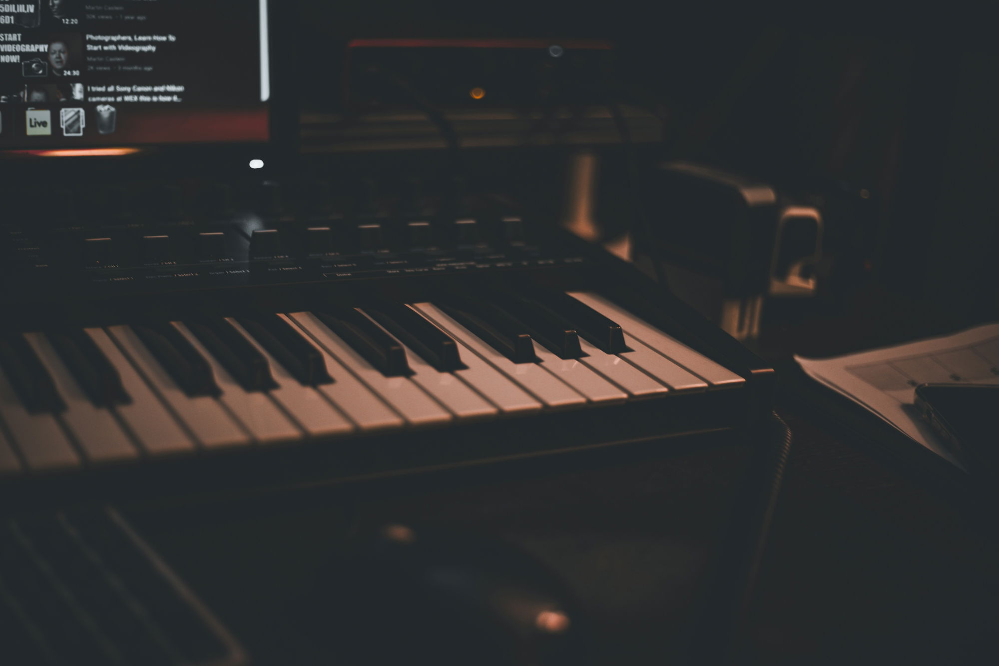 a close up of a keyboard with a computer in the background
